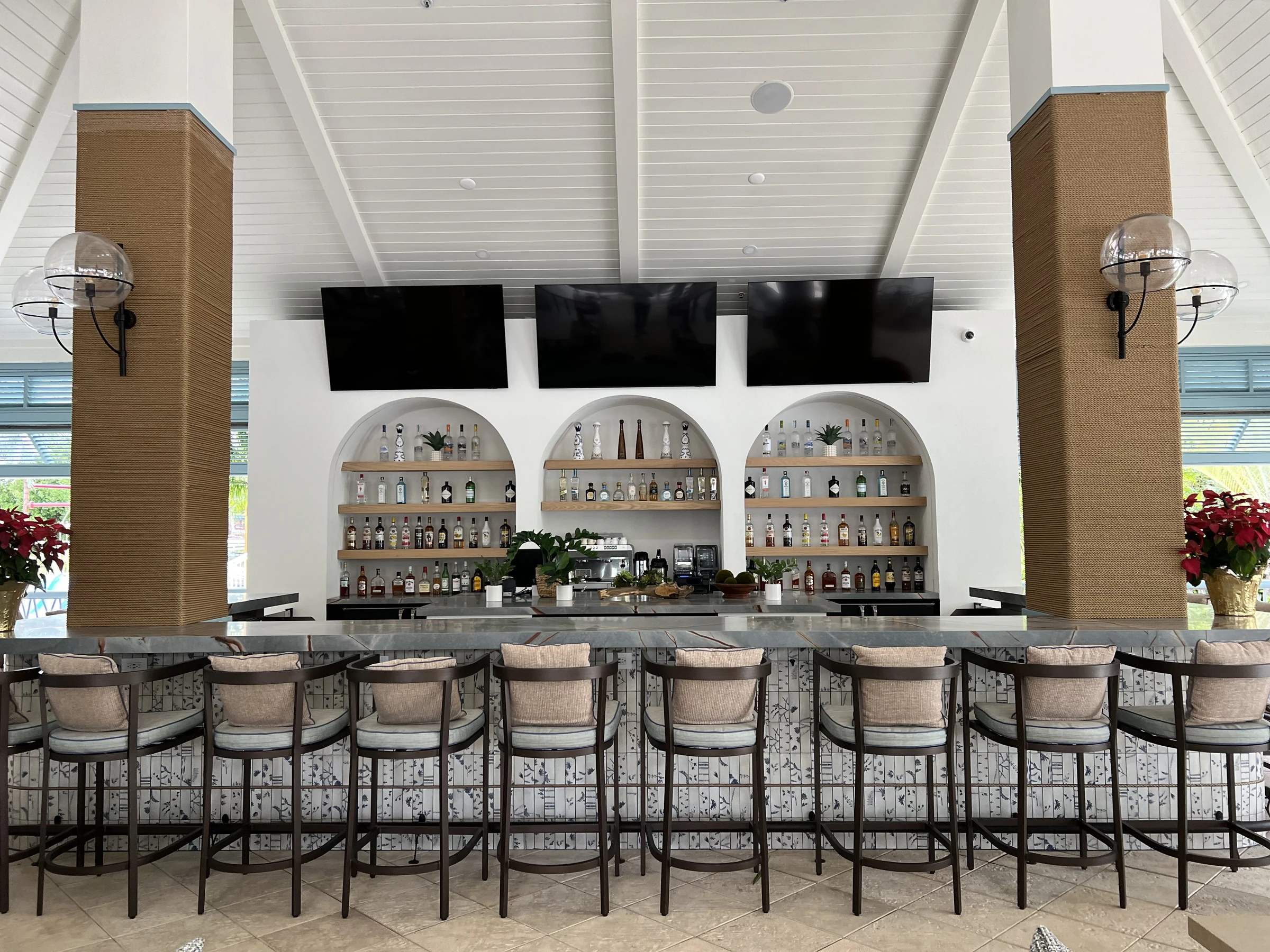 Footprints — Bar with woven stools and arched shelving