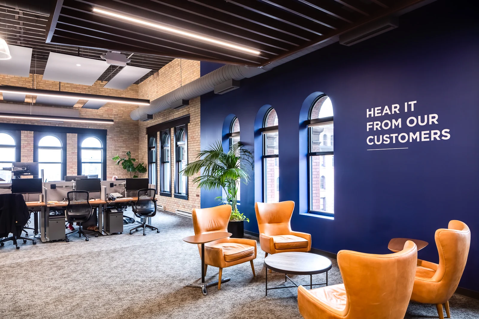 Portal Hospitality Club & Membership — Double-height atrium with lounge seating and long tables